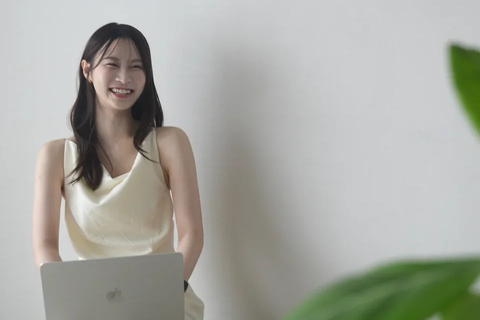 ノートパソコンを膝に、笑っているりかこ