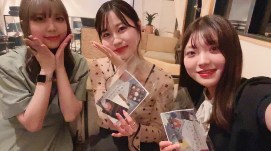 カフェでカードを持つ3人