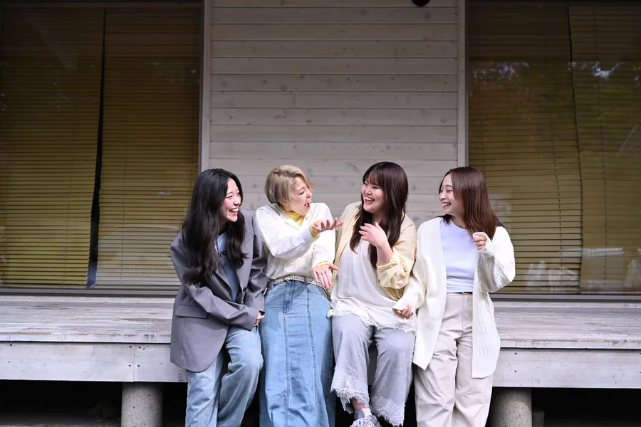 ウッドデッキに座って笑い合う4人